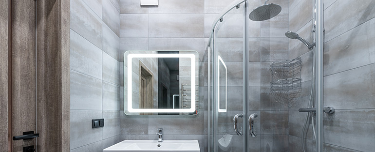 Qual a diferença entre ducha e chuveiro? | Banheiro com modelo de chuveiro inox redondo instalado no box | Blog Casa das Torneiras 